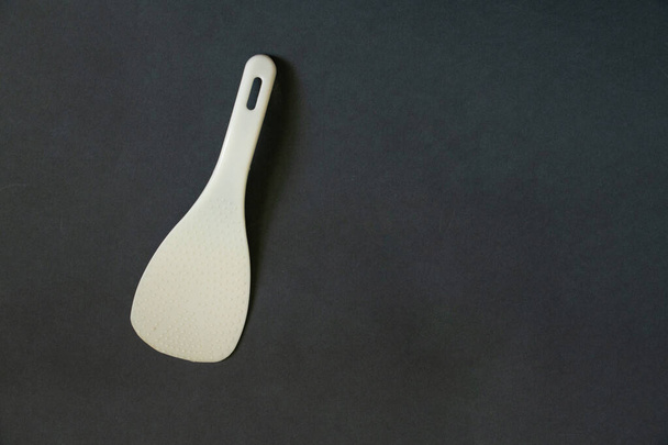 plastic white spoon for multicooker on a dark background - Zdjęcie, obraz