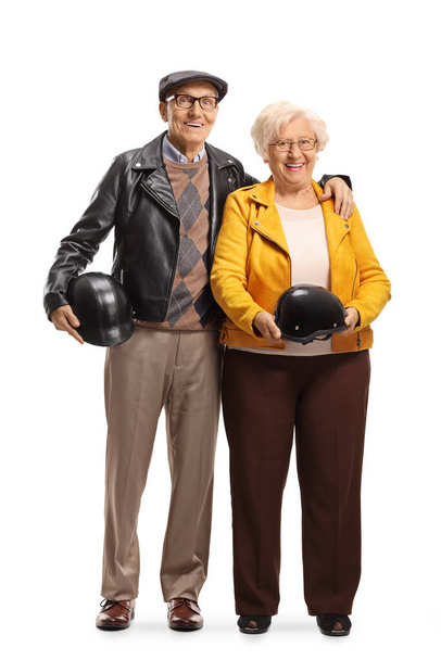 Full length portrait of a senior couple standing and holding helmets isolated on white background - Photo, image