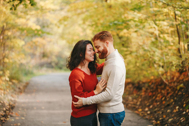 Portrait of beautiful couple man woman in love. Boyfriend and girlfriend hugging outdoor in park road path on autumn fall day. Togetherness and happiness. Authentic real people feelings. - Fotoğraf, Görsel