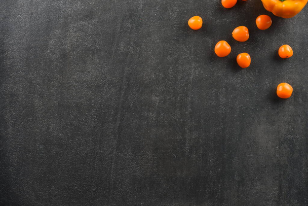 gelbe Tomaten und Paprika Gemüse auf grauem Stein Hintergrund für Lebensmittel - Foto, Bild