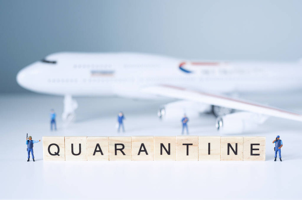 Group of toy people isolate a plane and its passengers. Quarantine concept. - Foto, immagini