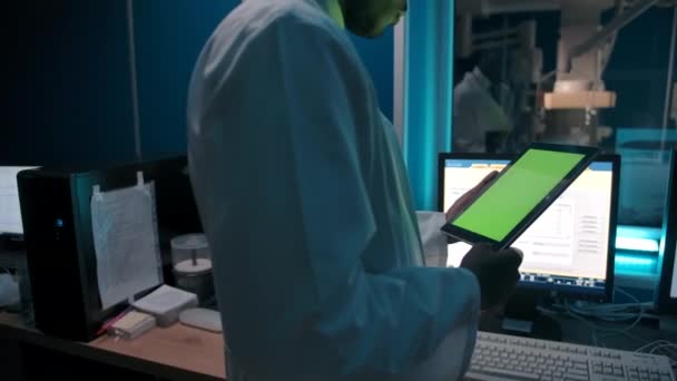Anonymní černý lékař čte data z tabletu v laboratoři - Záběry, video