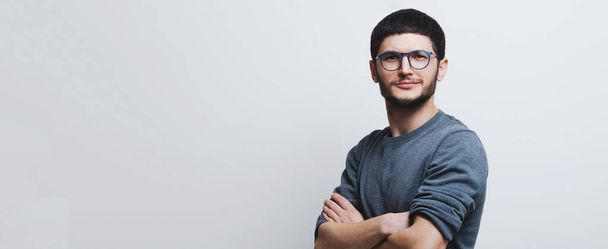 Panoramic banner, portrait of young confident guy with crossed arms wearing eyeglasses on white background with copy space. - Φωτογραφία, εικόνα