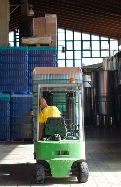 Trabajador de almacén cargando cajas de vino por carretilla elevadora
 - Foto, imagen