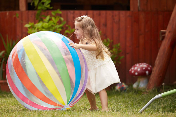 happy blonde girl playing with a big ball - Photo, Image