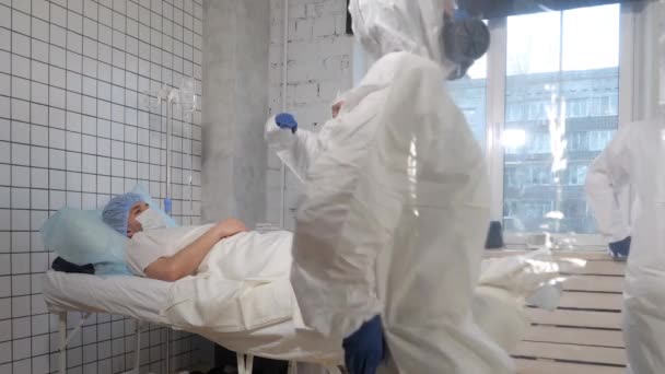 Artsen in beschermende pakken dansen in een ziekenhuiskamer. - Video