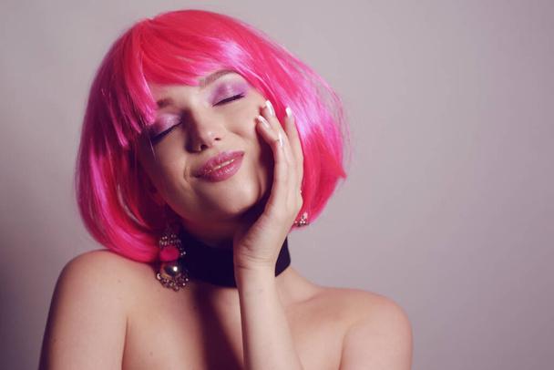 Kirkas tyttö, jolla on kirkkaat vaaleanpunaiset hiukset, iloitsee, tulee hulluksi, pitää hauskaa, grimaces. Positiivista energiaa. Kesätunnelmaa. Tyttö hymyilee ja nauraa vilpittömästi, epävirallinen kauneus. Musta mekko
. - Valokuva, kuva