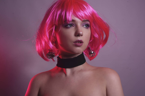 Portrait of a girl with pink hair and chic, fashionable earrings, pink earrings with silver. Jewelry, accessories. The girl shows a gesture of silence. Girl tells a secret. Hush. - Photo, Image