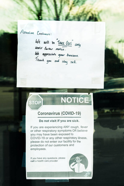 Take-out only and Covid-19 health signs taped to door of restaurant during time of Coronavirus pandemic - Photo, Image
