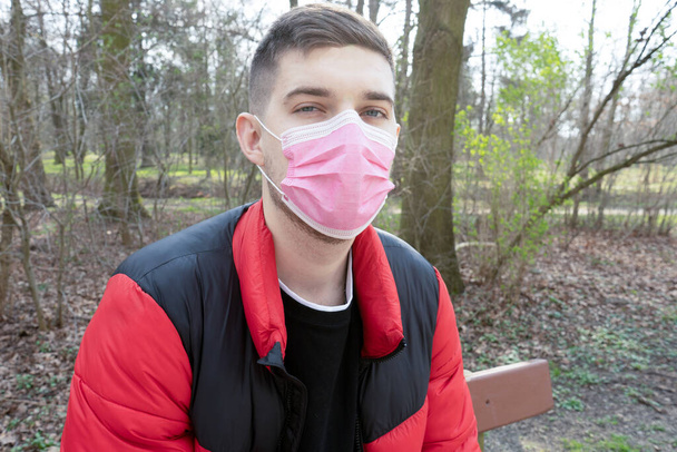 森林、コロナウイルス、病気、感染症、隔離、医療マスクの背景に外科包帯のブルネットの男の肖像 - 写真・画像