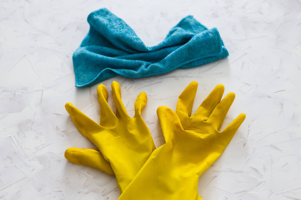 dezynfekcja i czyszczenie przed bakteriami i wirusami konceptualna martwa natura, żółte rękawice czyszczące i ściereczka z mikrofibry na wierzchu powierzchni do dezynfekcji - Zdjęcie, obraz