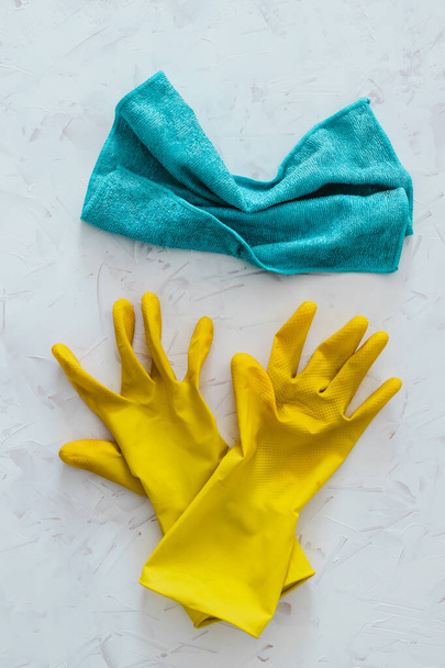 disinfecting and cleaning against bacteria and viruses conceptual still-life, yellow cleaning gloves and microfiber cloth on top of surface to be sanitized - Photo, Image