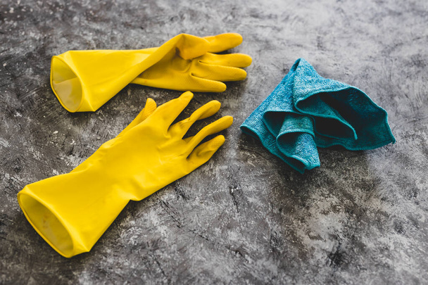 disinfecting and cleaning against bacteria and viruses conceptual still-life, yellow cleaning gloves and microfiber cloth on top of surface to be sanitized - Foto, Bild