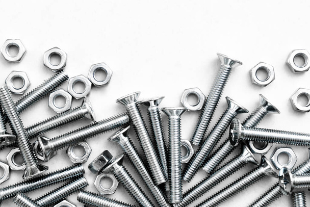 Top view of stainless steel bolts or iron nails on bright white background with silver color. Metal screws for use in sheet metal. - Fotoğraf, Görsel