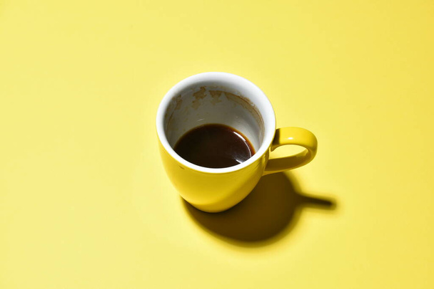 yellow half drinked cup of coffee on paper  background   - Φωτογραφία, εικόνα