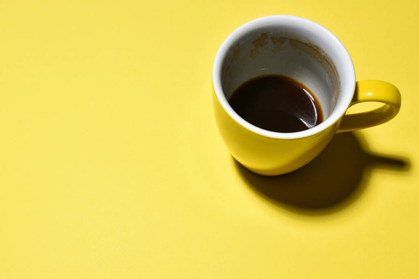 gelbe halb getrunkene Tasse Kaffee auf Papier Hintergrund   - Foto, Bild