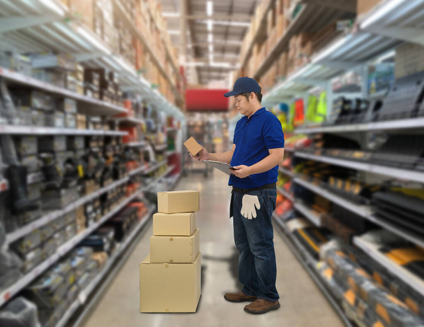 Personal masculino y cajas de embalaje que verifican el stock o preparan las mercancías para el envío y difuminan el fondo del almacén - Foto, imagen