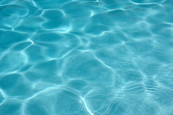 Закройте полный обзор водной поверхности бассейна с солнечным освещением
 - Фото, изображение