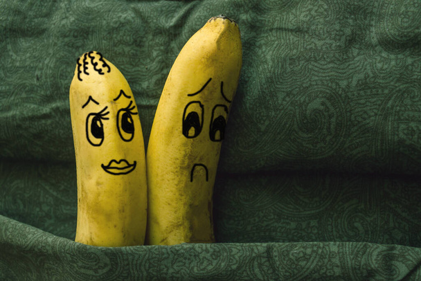 Impotentie, gebrek aan aantrekkingskracht op zijn vrouw, seksuele kou. Twee bananen, echtgenoten, in een familiebed. De vrouw flirt, haar man keert zich af. De foto is gemaakt door de auteur. - Foto, afbeelding
