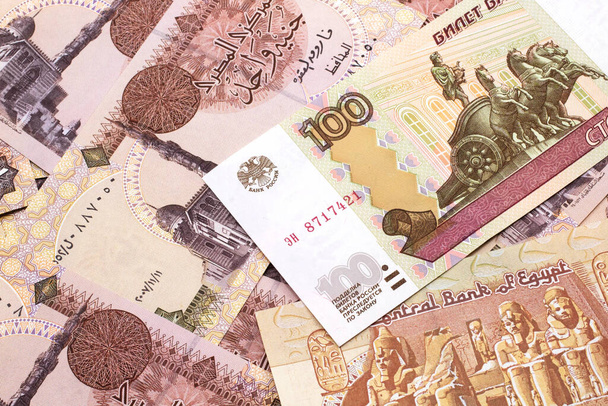 Une image rapprochée d'un billet de banque de cent roubles sur un fond de billets de livre égyptienne du Mexique. Plan rapproché dans macro
 - Photo, image