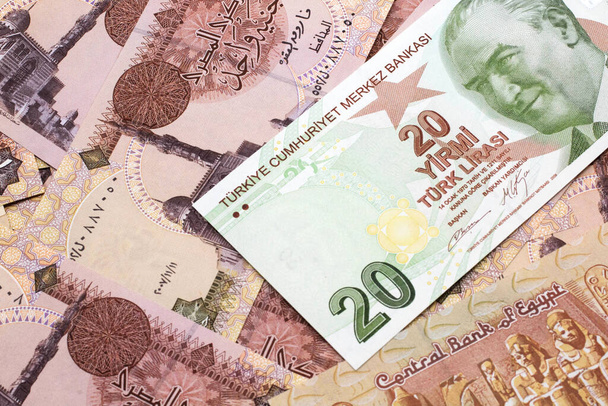 A close up image of a green twenty Turkish lira bank note on a background of Egyptian one pound bank notes in macro - Photo, Image