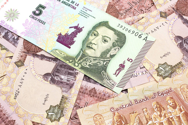 Un billet de banque argentin de cinq pesos sur fond de billets de banque égyptiens d'une livre close up
 - Photo, image