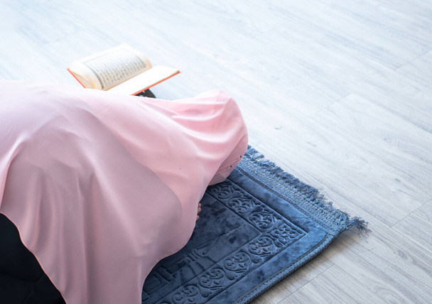 boční pohled na asijské krásné mladé muslimské studentky modlitba v hidžábu modlí na koberci rohože uvnitř - Fotografie, Obrázek