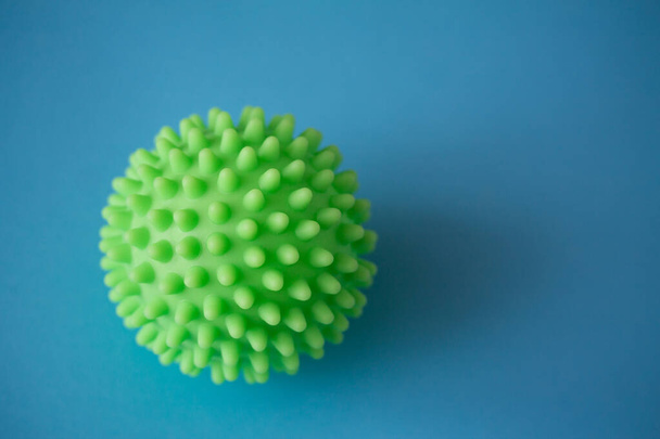 Close up de modelo de coronavírus verde spiky isolado em fundo azul. A doença pandémica espalhou-se por todo o mundo. Tratamento médico das pessoas infectadas. Serviços de saúde
 - Foto, Imagem