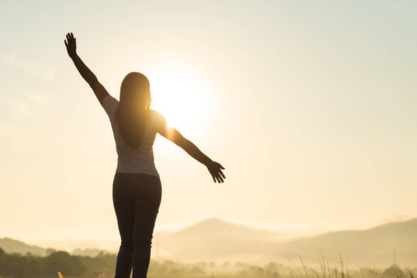 Silhouette of happy woman spreading arms and watching the mountain. Travel Lifestyle success concept adventure active vacations outdoor freedom emotions. - Foto, Imagem