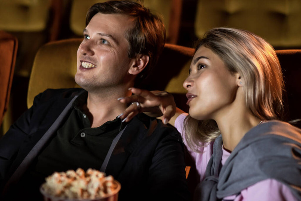 Kaukaski kochanek korzystających do oglądania filmów i jedzenia popcornu razem w kinie - Zdjęcie, obraz