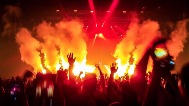 Happy people dansen in nachtclub DJ party concert en luisteren naar elektronische dansmuziek van DJ op het podium. Silhouet vrolijke menigte vieren Nieuwjaarsfeest 2020. Mensen levensstijl DJ nachtleven. - Foto, afbeelding