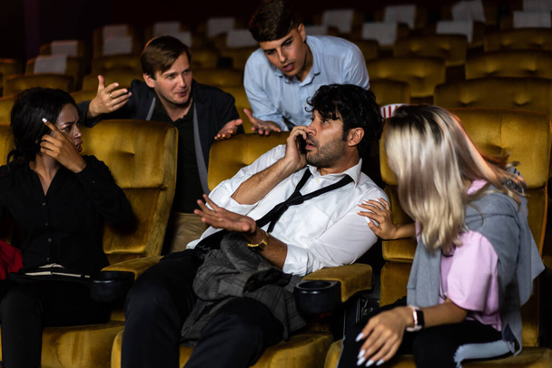 Раздражающий человек разговаривает по мобильному телефону в кинотеатре люди в кино злится его - Фото, изображение