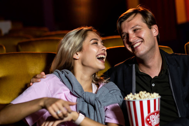 Caucasian lover enjoying to watch movie and eating popcorn together in the cinema - Foto, Imagen