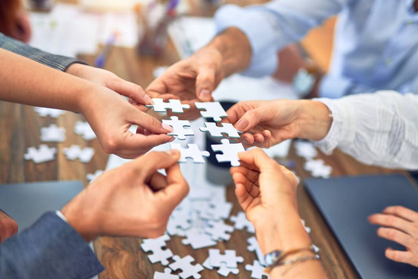 Gruppo di imprenditori con mani unite che collegano pezzi di puzzle in ufficio
 - Foto, immagini