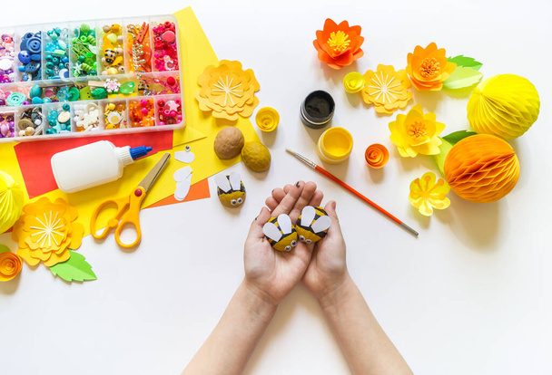 The child makes a bee crafts. Paints and material for creativity. Kindergarten and school. White background - Foto, Imagem