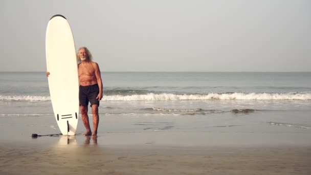 Старий зрілий чоловік з дошкою для серфінгу на фоні моря
 - Кадри, відео