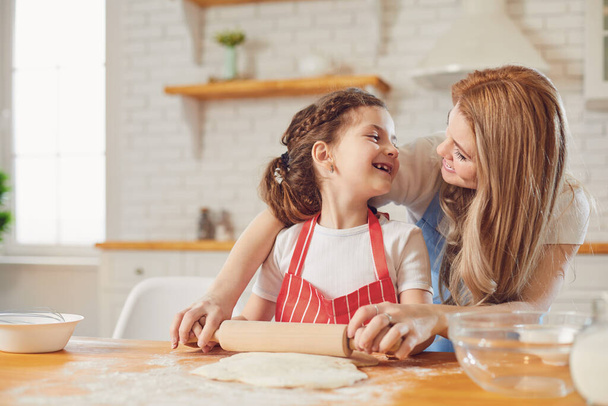 Mother and daughter prepare flour baked goods on a table in the kitchen. Happy mothers day - Foto, Imagem