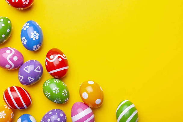 Плоская композиция с пасхальными яйцами на цветном фоне. Рамка из украшенных яиц. Вид сверху с местом для текста
 - Фото, изображение