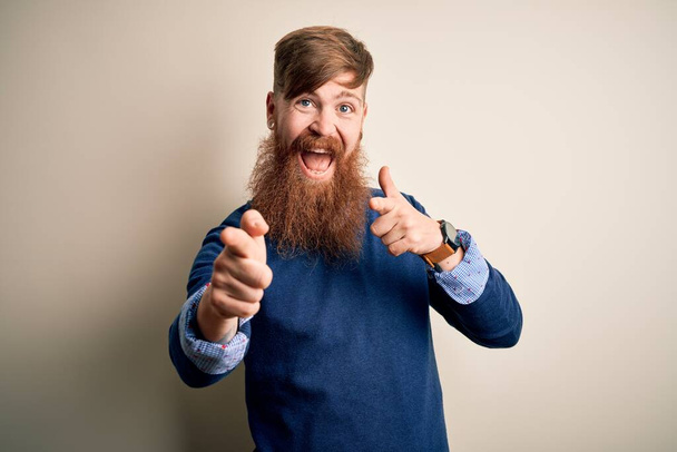 Beau roux irlandais homme d'affaires avec barbe debout sur fond isolé pointant les doigts vers la caméra avec un visage heureux et drôle. Bonne énergie et vibes
. - Photo, image