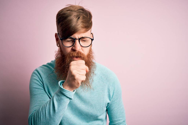 Handsome Irish redhead man with beard wearing glasses over pink isolated background feeling unwell and coughing as symptom for cold or bronchitis. Health care concept. - Photo, Image