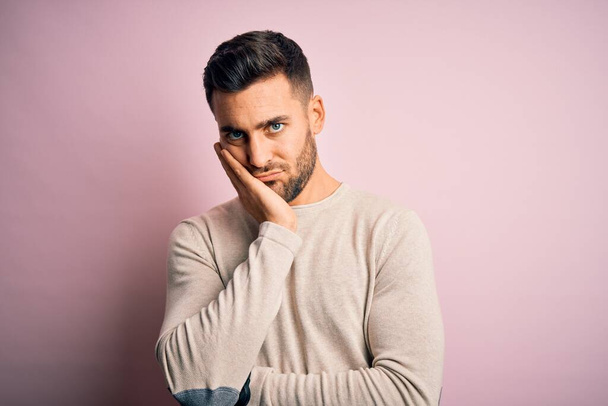 Young handsome man wearing casual sweater standing over isolated pink background thinking looking tired and bored with depression problems with crossed arms. - Φωτογραφία, εικόνα