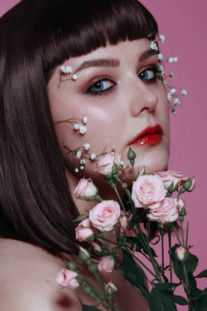 Close up studio beauty portrait of young beautiful woman with fresh, smooth, flawless skin, nude makeup with flower on pink background. Fashion photo - Φωτογραφία, εικόνα