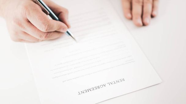 Gros plan d'un homme d'affaires signant un contrat de location avec un stylo
. - Photo, image