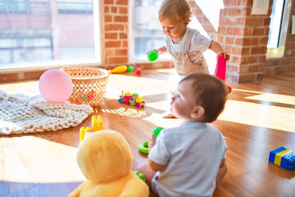 Crianças bonitas brincando em torno de lotes de brinquedos no jardim de infância
 - Foto, Imagem