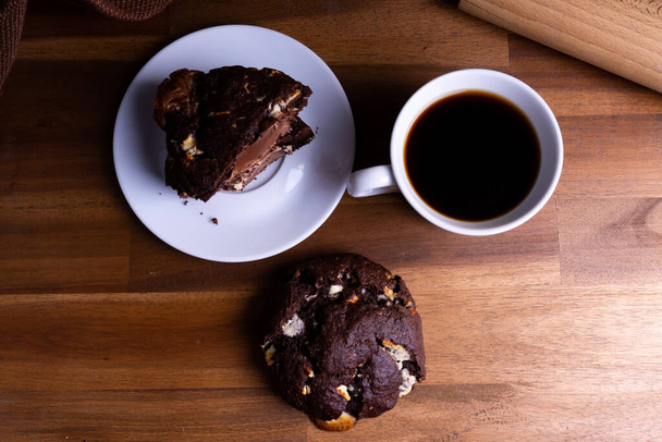 Delicious cookie cakes with chocolate with a cup of coffee on a wooden board with copy space - Zdjęcie, obraz