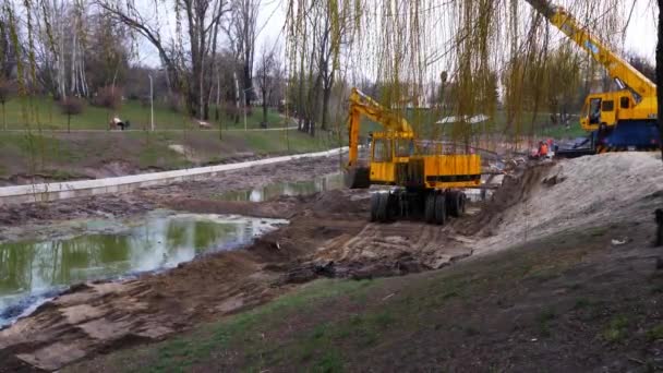 excavadora cava tierra cerca de un lago
 - Metraje, vídeo