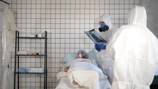 Пацієнт з вентиляцією легень і лікар з рентгенівським зображенням у лікарні
. - Кадри, відео