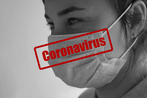 Girl nurse in medical mask. Coronavirus inscription in the photograph. Concept of a monochrome image of a woman in a protective mask against viruses and other diseases. - Φωτογραφία, εικόνα