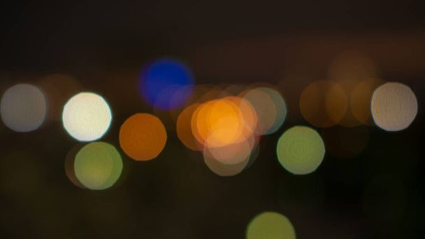 Bokeh image of blurred lighting, circle shape of shiny lights from the city in dark  night - Foto, immagini