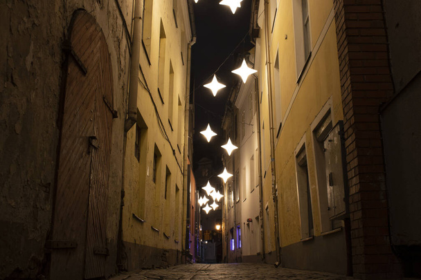 Night view of the narrowest street of Riga-Rosen Street with lanterns in the form of stars, Latvia - Foto, imagen
